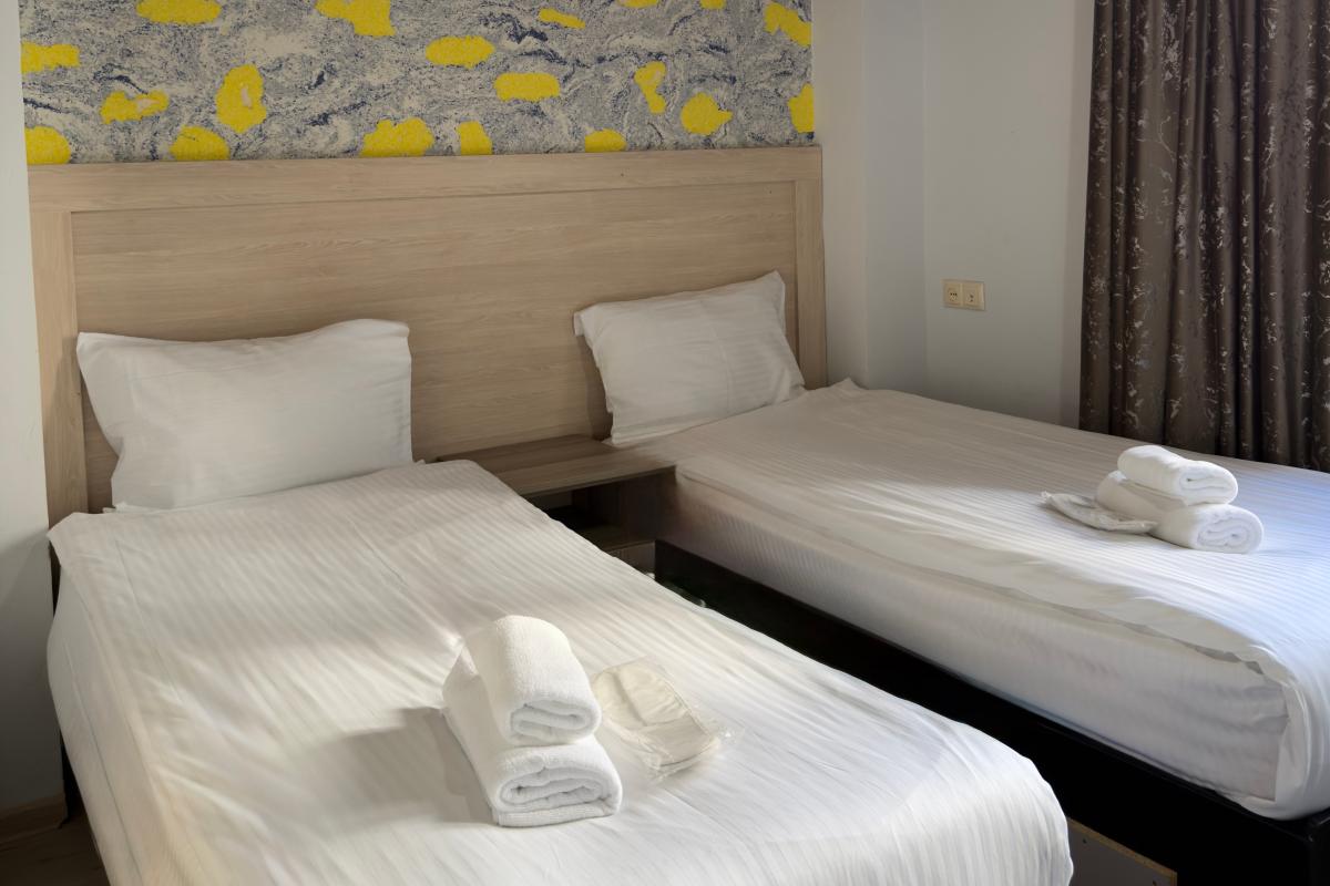 Twin room at Akman Swiss Hotel with two separate beds and air conditioning